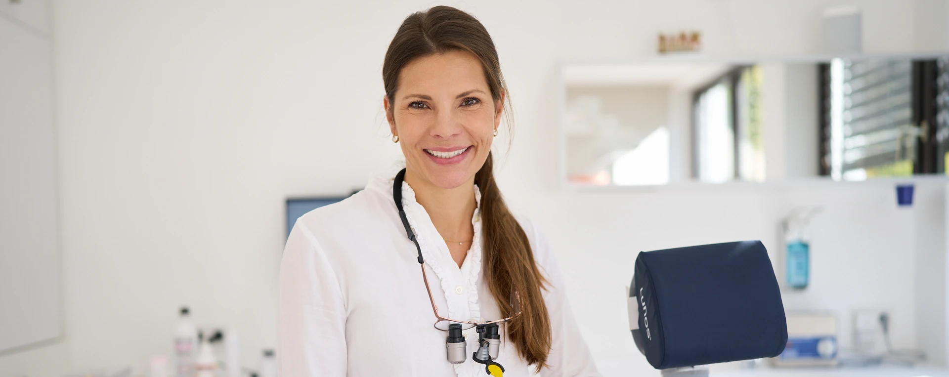 Dr. Anna Plössner, Zahnärztin in München-Solln, lächelt in ihrer Praxis