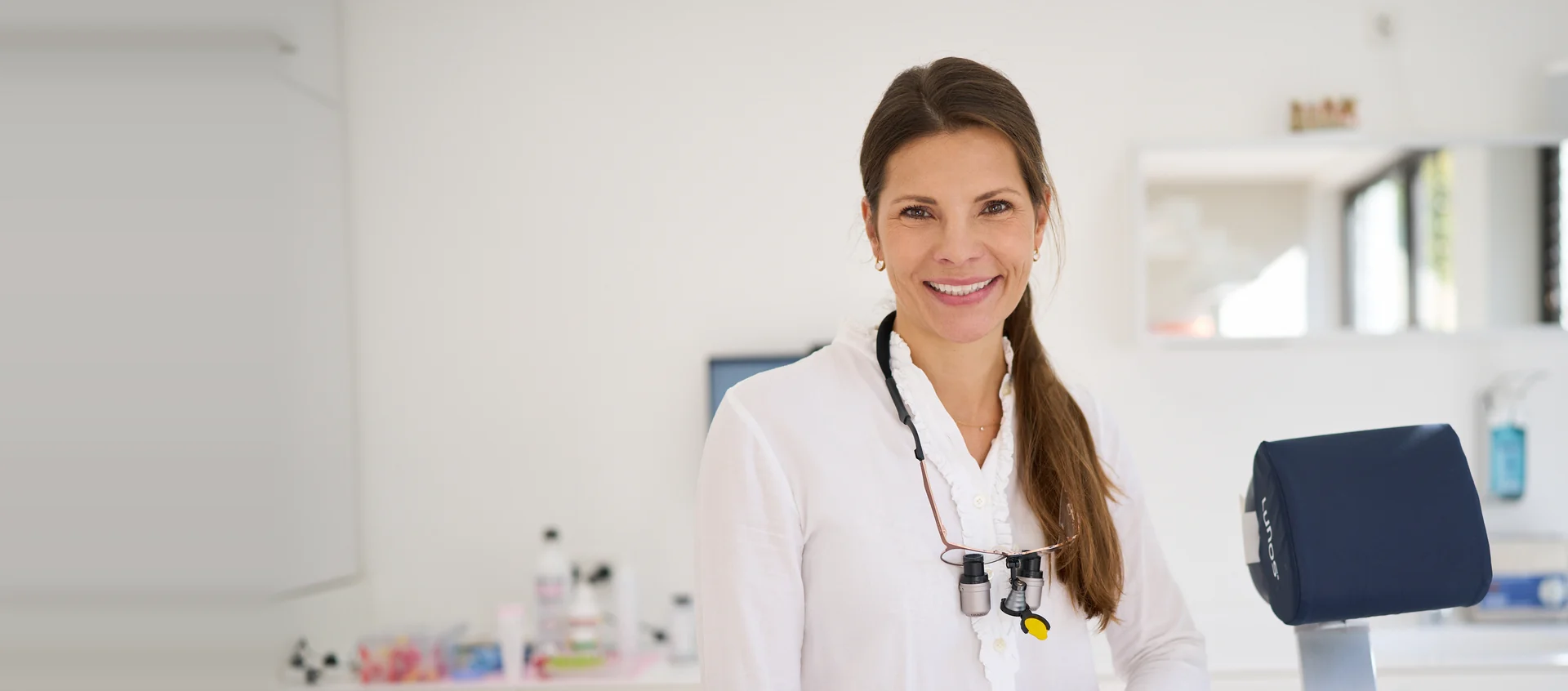 Dr. Anna Plössner, Zahnärztin in München-Solln, lächelt in ihrer Praxis